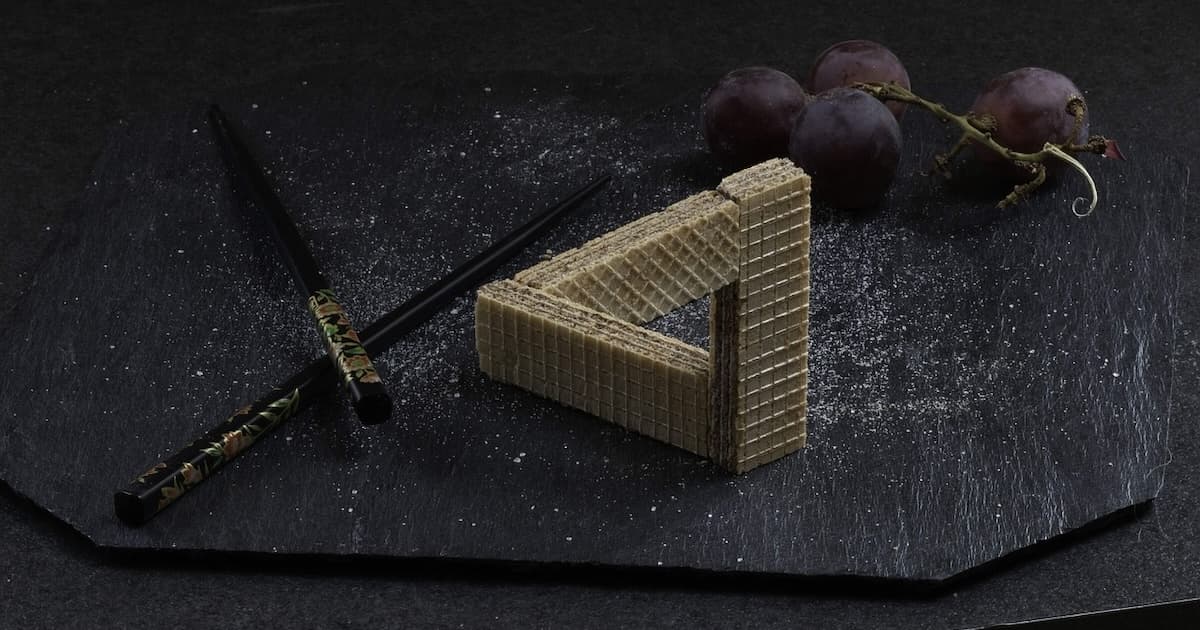 Penrose Triangle optical illusion created out wafer biscuits. Image by Emmanuel Lefebvre from Pixabay.